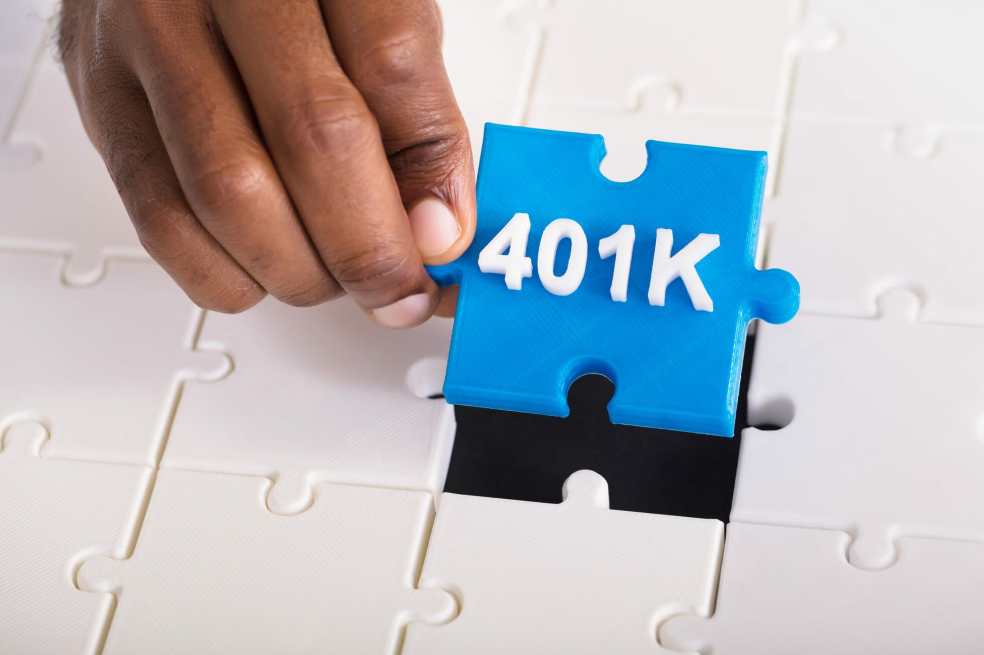 Blue 401k puzzle piece being inserted into puzzle