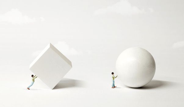 Figure pushing a square block and a sphere