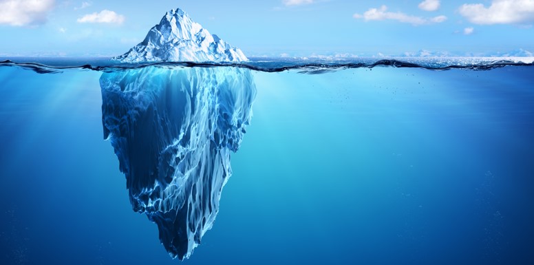 Photo of iceberg in water. Majority of iceberg mass is under the surface of the water.
